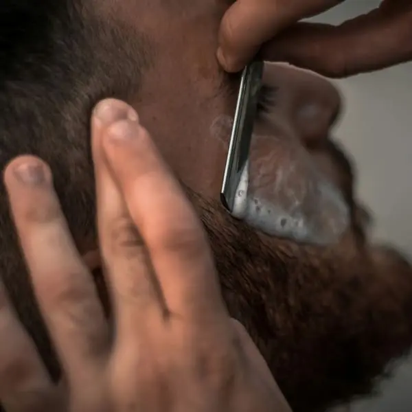 Barbero trabajando con tijera en el sillón